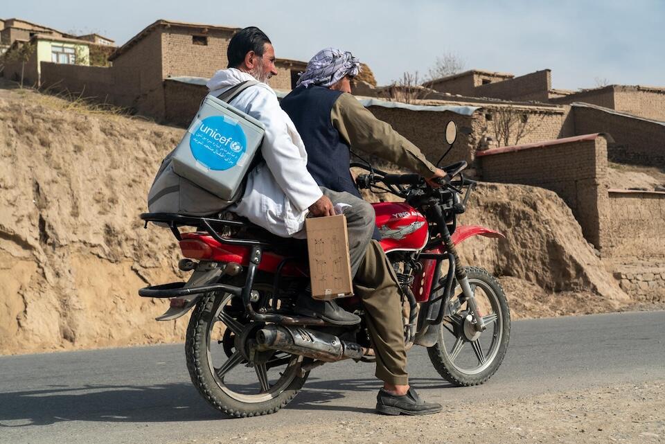 On Nov. 7, 2023, vaccinator Sayed Nasrullah Atayee, carrying a cold box full of vaccines, sets out by motorcycle from Layaba Basic Health Clinic in Layaba village, Fayzabad district, Badakhshan Province, Afghanistan.